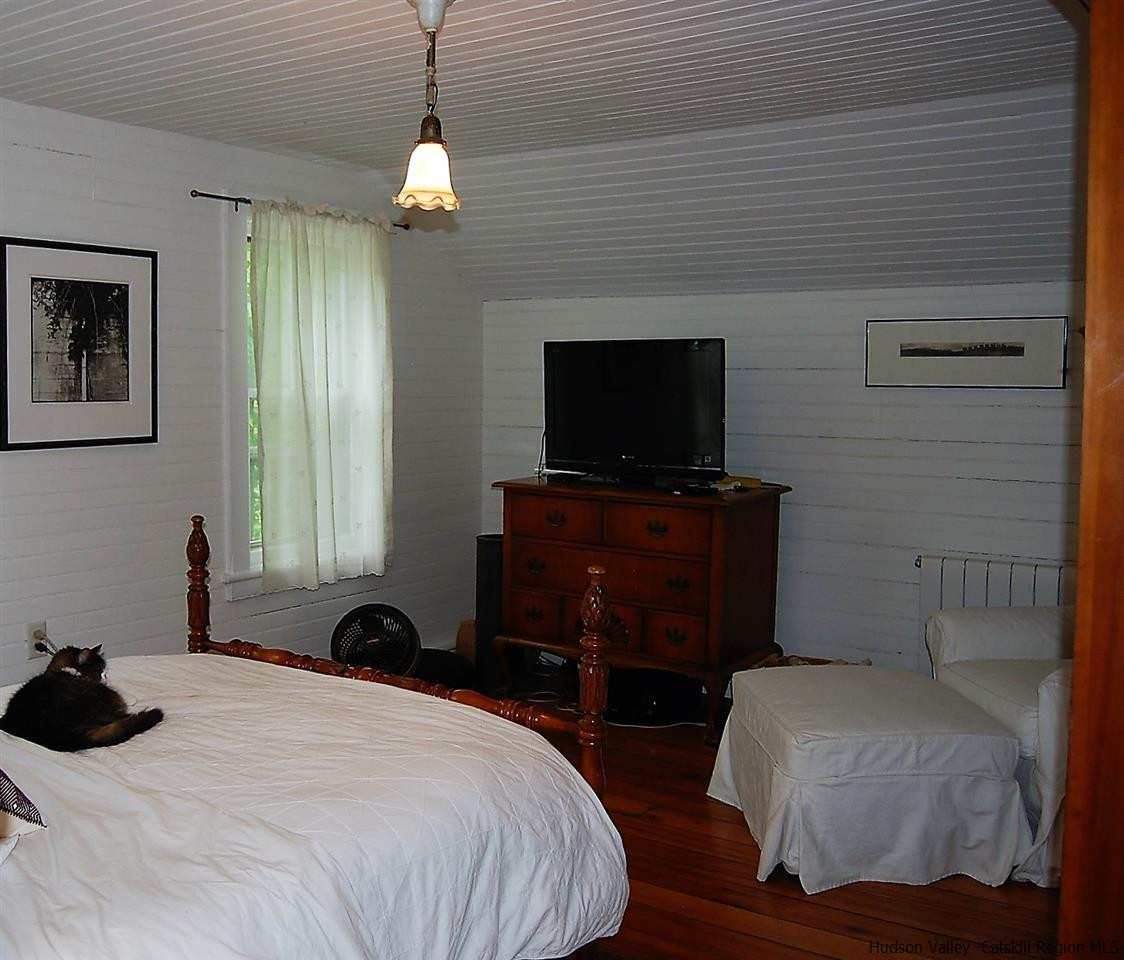 3424 Cooper Street Stone Ridge, NY 12484 - Photo 15 of 24 a bedroom with a bed and a flat tv screen on dresser