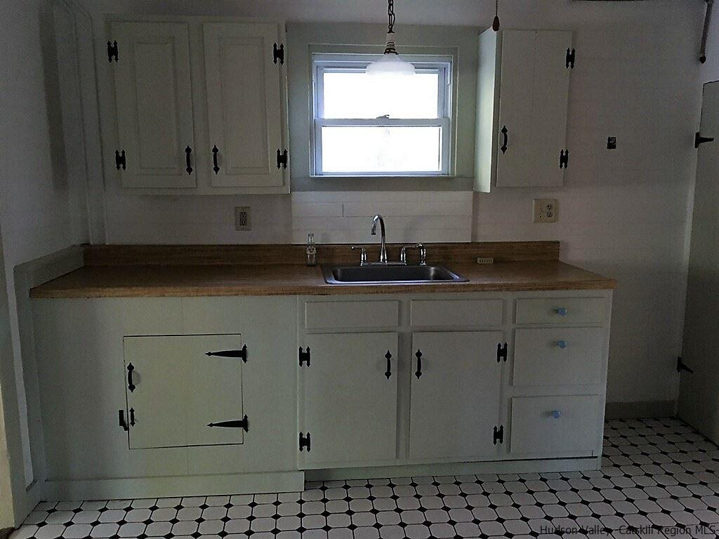 3424 Cooper Street Stone Ridge, NY 12484 - Photo 4 of 24 a bathroom with granite countertop white cabinets and a sink