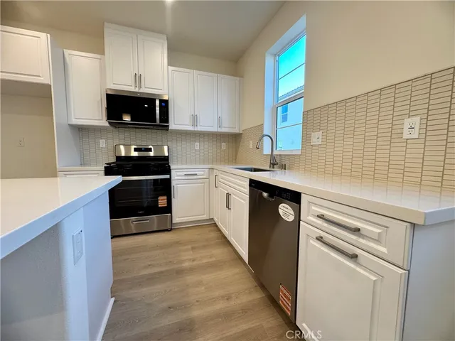 a kitchen with stainless steel appliances a sink dishwasher stove and microwave
