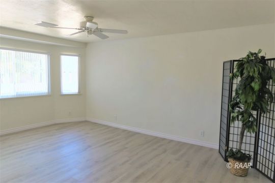 1122 North Inyo Street Ridgecrest, CA 93555 - Photo 4 of 34 wooden floor in an empty room with a window