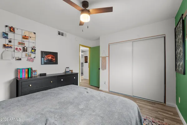 a bedroom with a bed and a computer on the dresser