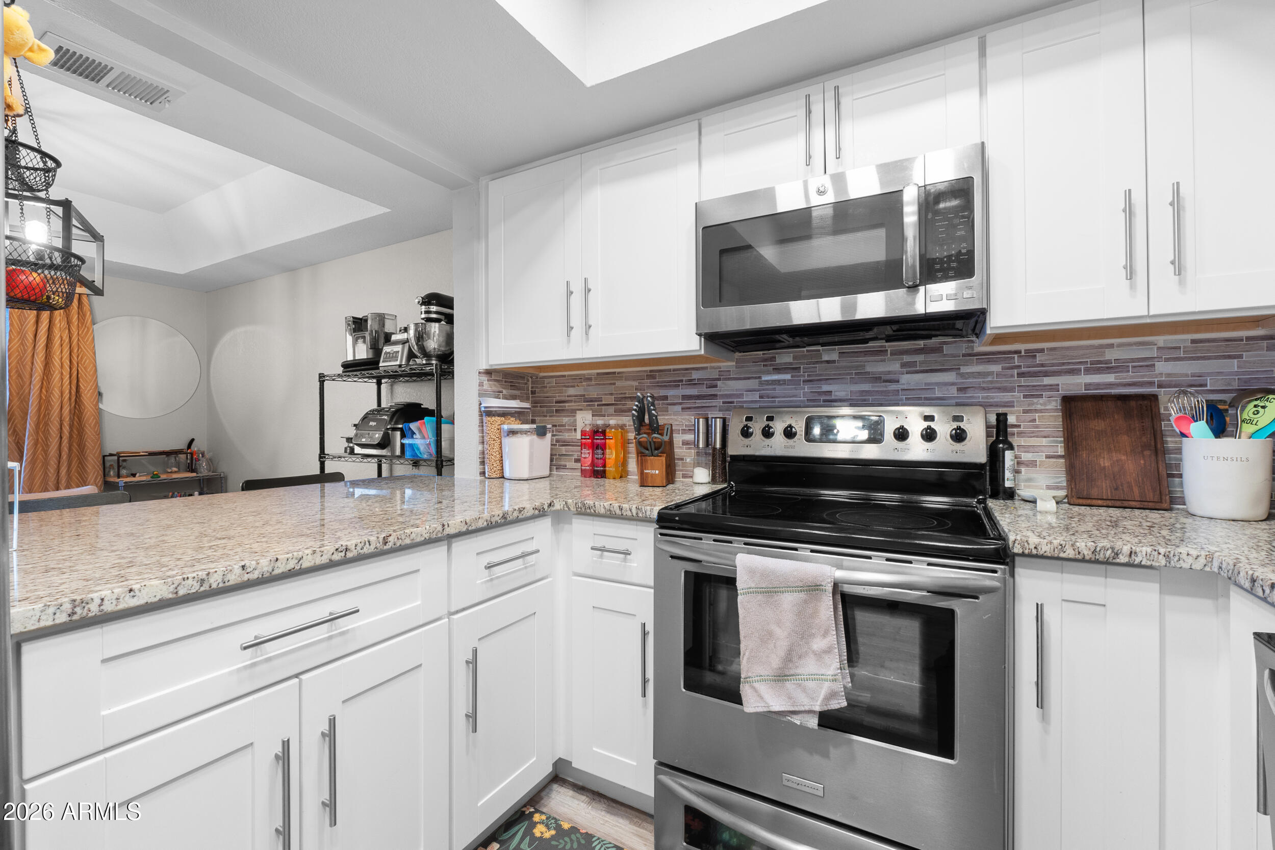 202 East Ruth Avenue, Unit 2 Phoenix, AZ 85020 - Photo 8 of 25 a kitchen with granite countertop a stove top oven microwave and cabinets