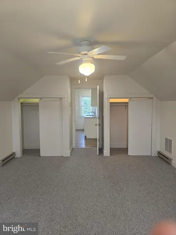 a view of empty room with window and ceiling fan