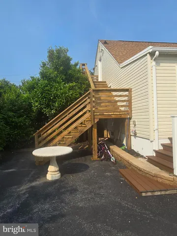 a view of backyard with stairs and a chair