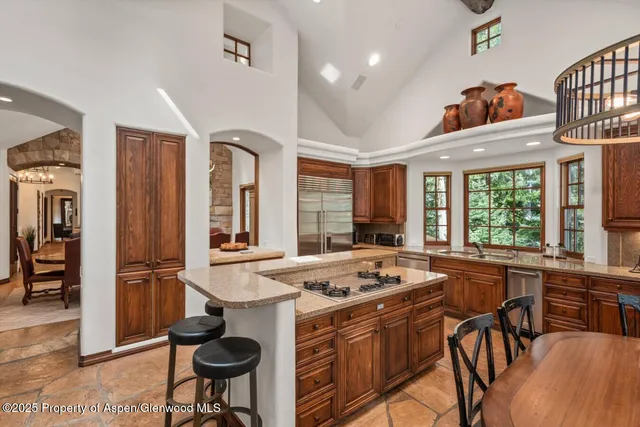 a view of kitchen island dining area kitchen island stainless steel appliances wooden floor and living room view