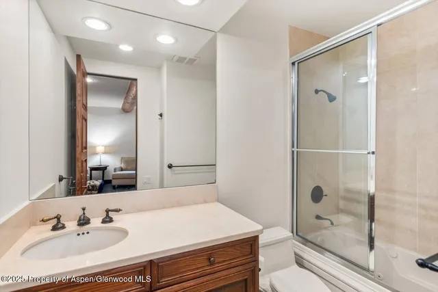 a spacious bedroom with a bed a couch and a large window