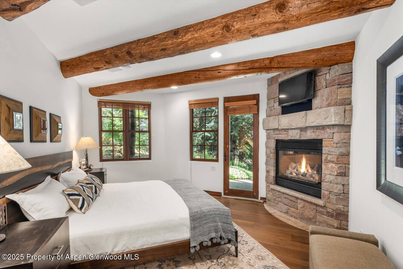 27 Timber Ridge Lane Snowmass Village, CO 81615 - Photo 32 of 40 a bed sitting in a bedroom next to a fireplace with a window