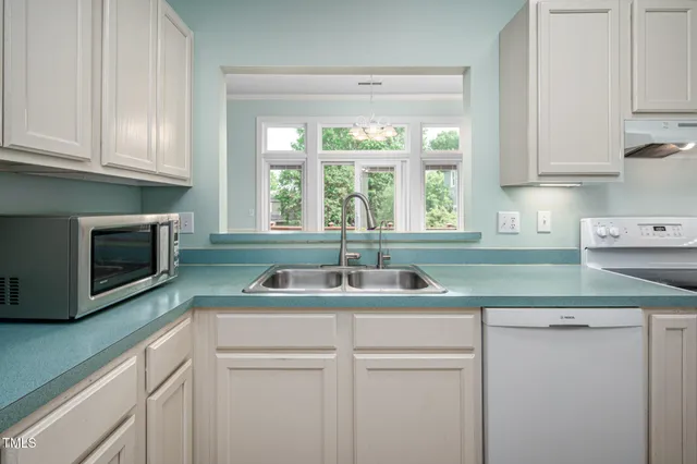 a kitchen with white cabinets and a sink