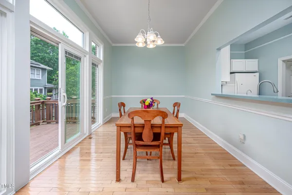 a dining room with furniture a chandelier and wooden floor