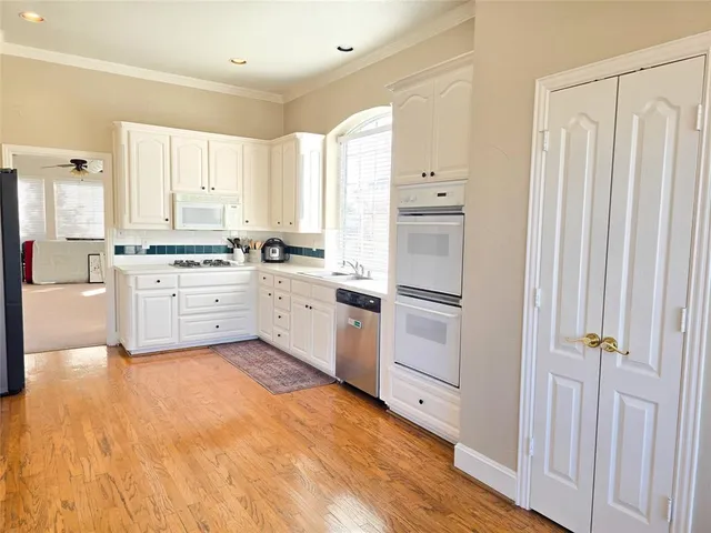 a kitchen with white cabinets and white appliances