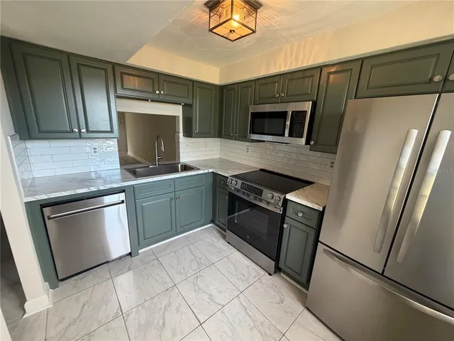 a kitchen with stainless steel appliances granite countertop a stove microwave and refrigerator