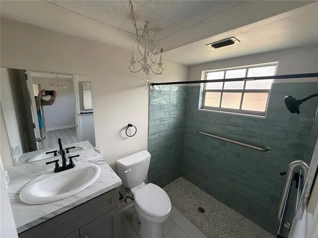 a bathroom with a sink toilet a mirror and shower