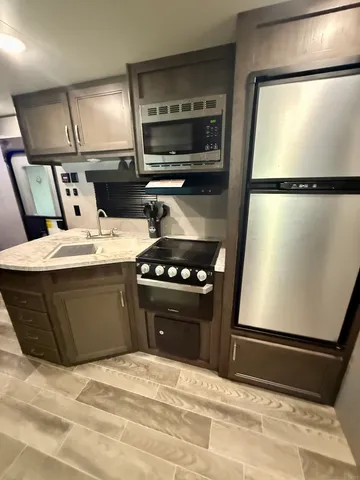 a kitchen with a refrigerator and a stove top oven