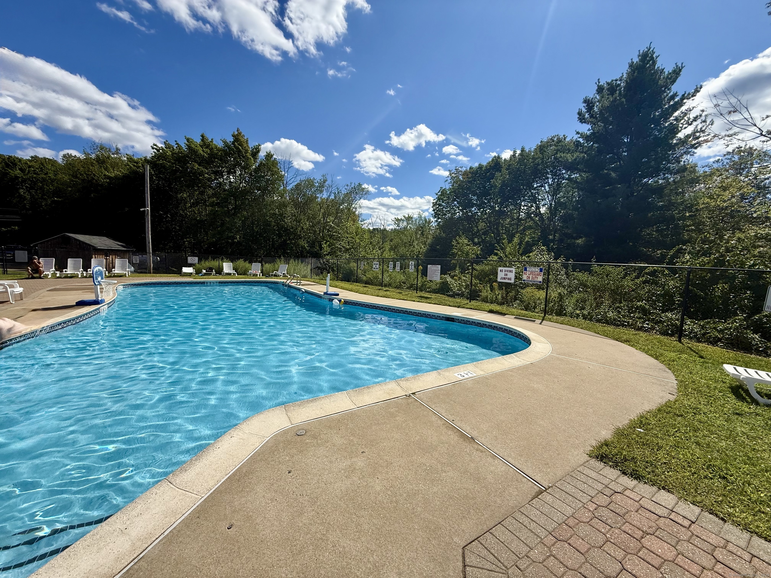 8 S Road, Unit R80 Stafford, CT 06076 - Photo 30 of 36 a view of a swimming pool with a lounge chair and tables back yard of the house