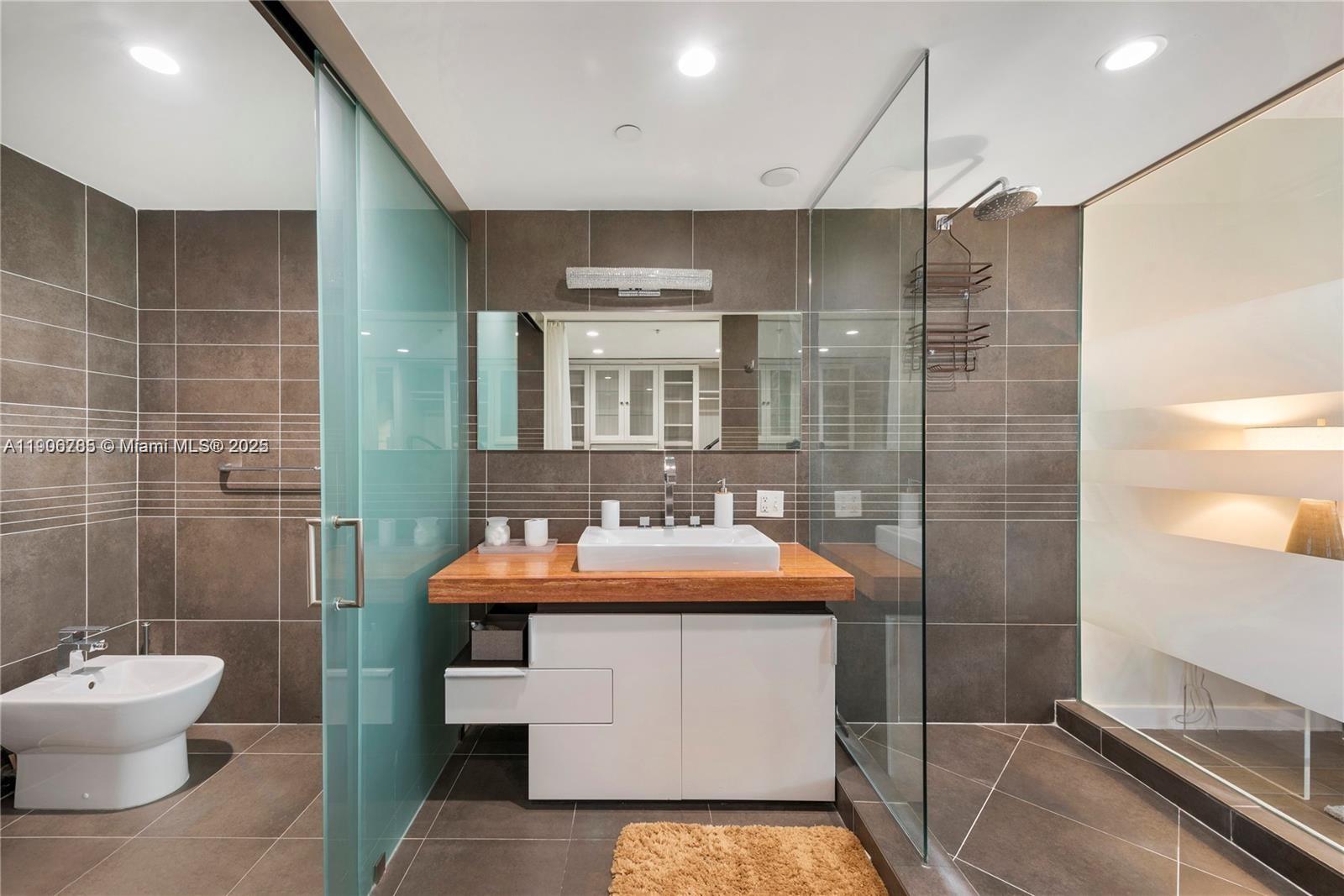 2155 Washington Court, Unit 309 Miami Beach, FL 33139 - Photo 13 of 23 a bathroom with a sink a toilet and shower