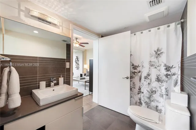 a bathroom with a sink a toilet and shower curtain