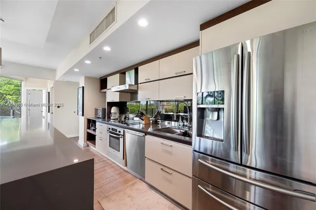 a kitchen with stainless steel appliances granite countertop a refrigerator and a stove