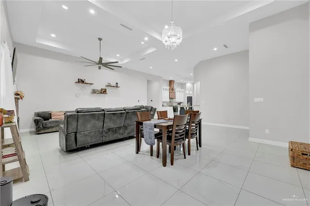 a dining hall with stainless steel appliances kitchen island granite countertop a table and chairs in it