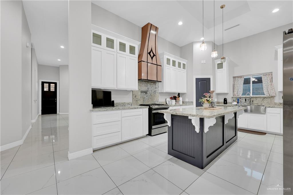 522 La Pointe Avenue Alton, TX 78573 - Photo 7 of 25 a kitchen with stainless steel appliances kitchen island granite countertop a sink and cabinets