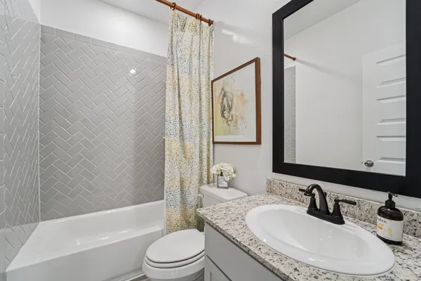 a bathroom with a granite countertop sink toilet tub and shower