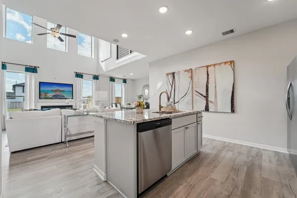 a kitchen with stainless steel appliances granite countertop a sink and dishwasher with wooden floor