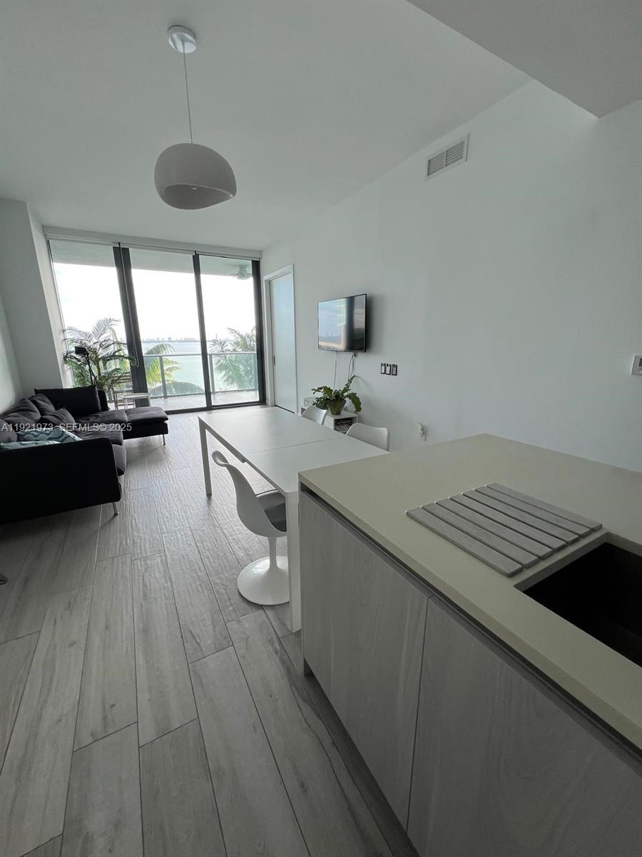 480 Northeast 31st Street, Unit 804 Miami, FL 33137 - Photo 25 of 39 a open kitchen with a sink stove and wooden floor