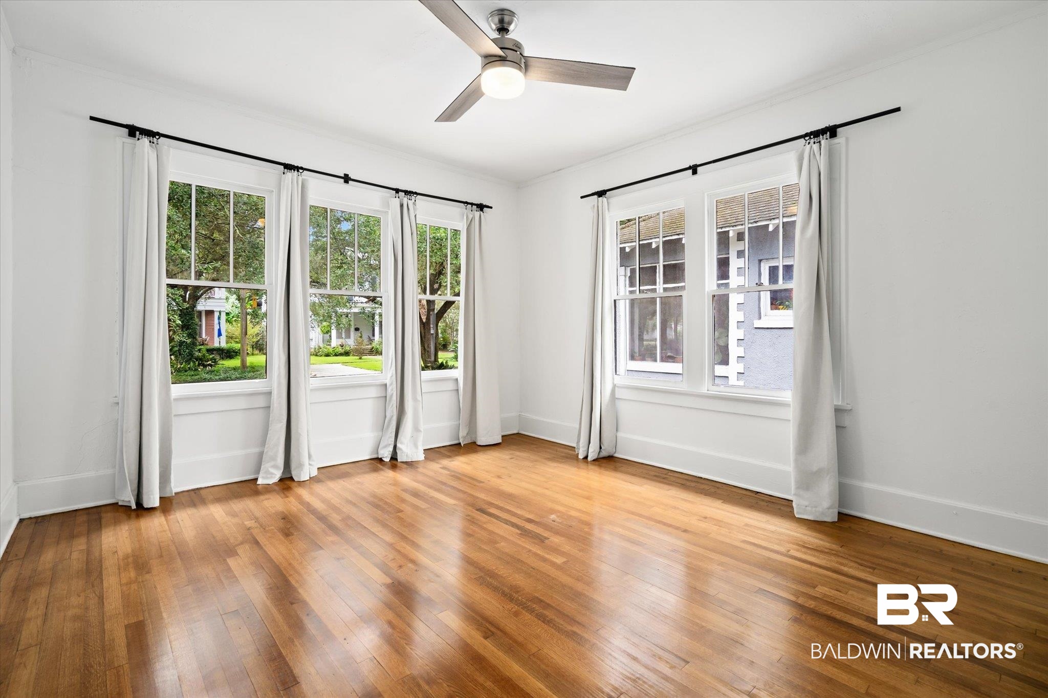 308 South Ann Street Mobile, AL 36604 - Photo 19 of 30 Empty room featuring light wood-type flooring, a healthy amount of sunlight, and ceiling fan