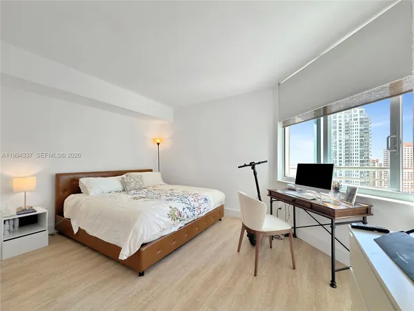 a bedroom with a bed and a flat screen tv
