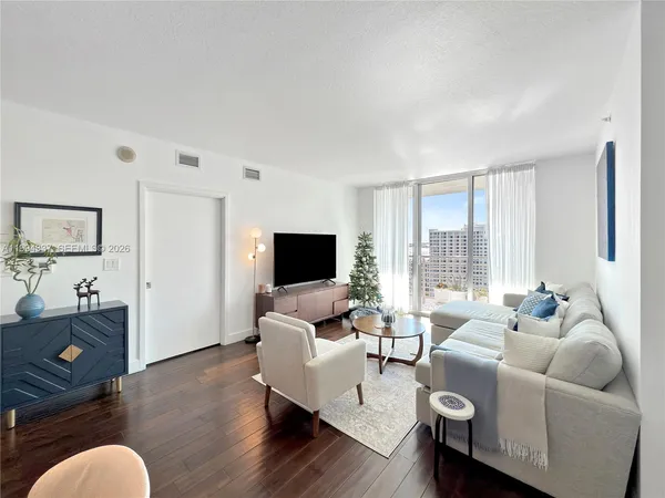 a living room with furniture or kitchen view and a wooden floor