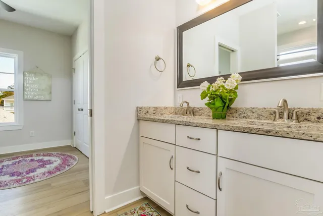 a bathroom with a granite countertop sink and a mirror