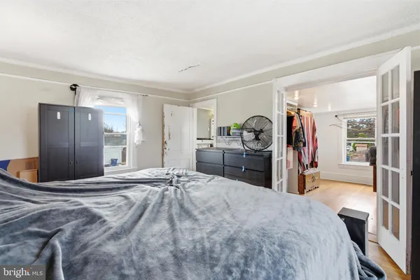 a large bedroom with a bed and a large mirror on the dresser