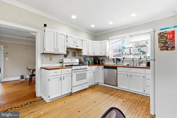 a kitchen with granite countertop white cabinets and white appliances