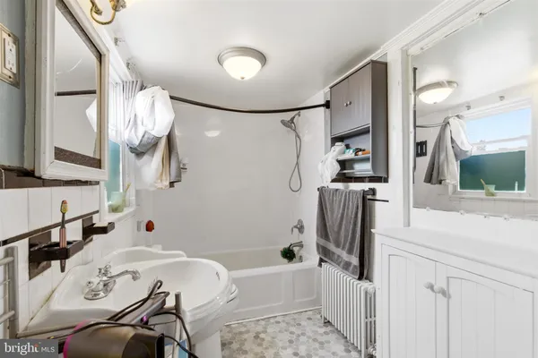 a bathroom with a bathtub sink and mirror