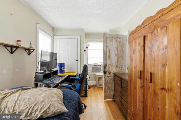 a bedroom with a bed and wooden floor