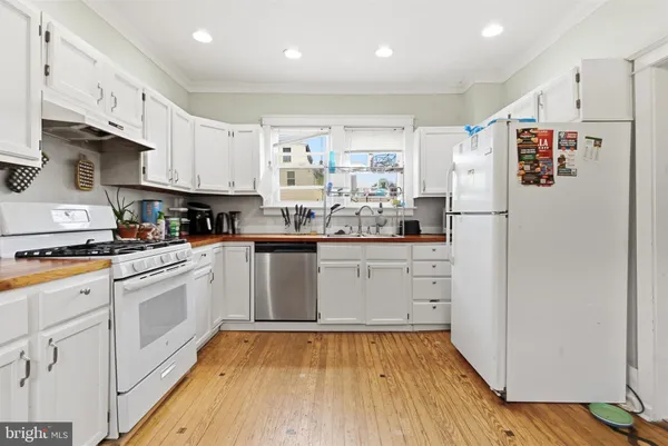 a kitchen with white cabinets and white appliances