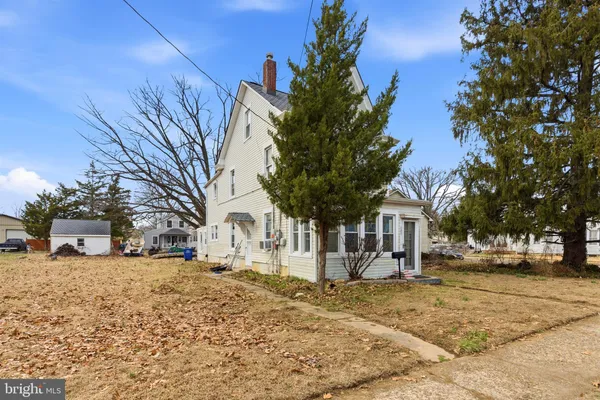 a view of a white house with a yard and large tree