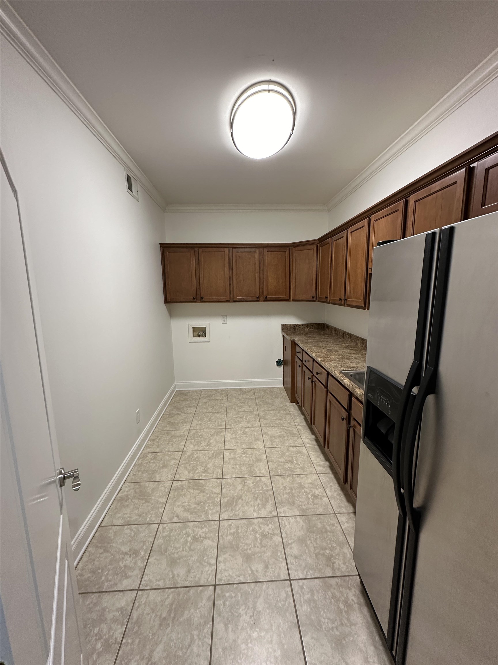 55 Hickory Nut Road Piperton, TN 38017 - Photo 18 of 40 Kitchen with light tile patterned floors, baseboards, visible vents, stainless steel fridge with ice dispenser, and crown molding