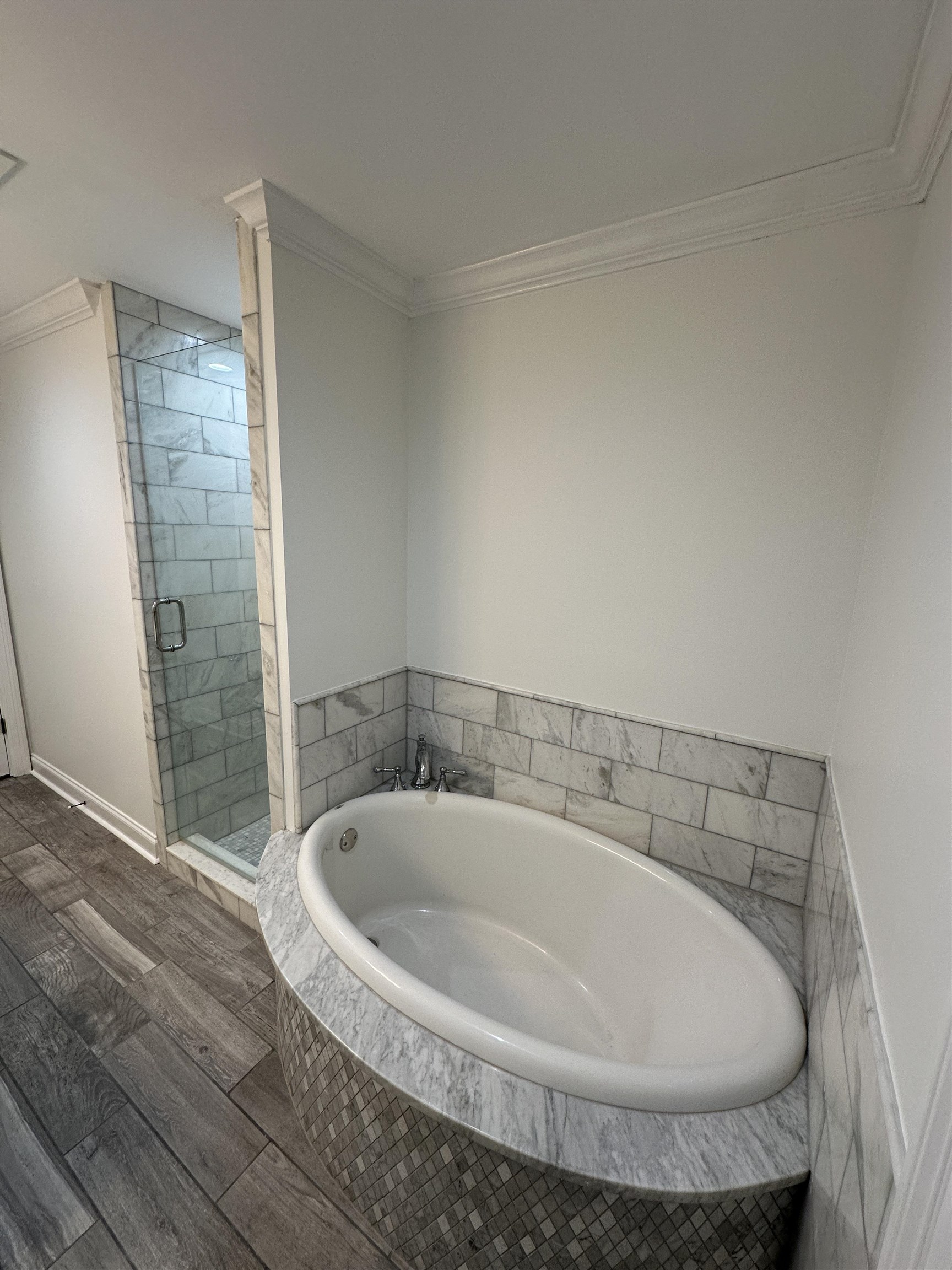 55 Hickory Nut Road Piperton, TN 38017 - Photo 31 of 40 Full bath with wood finish floors, a garden tub, a shower stall, crown molding, and baseboards