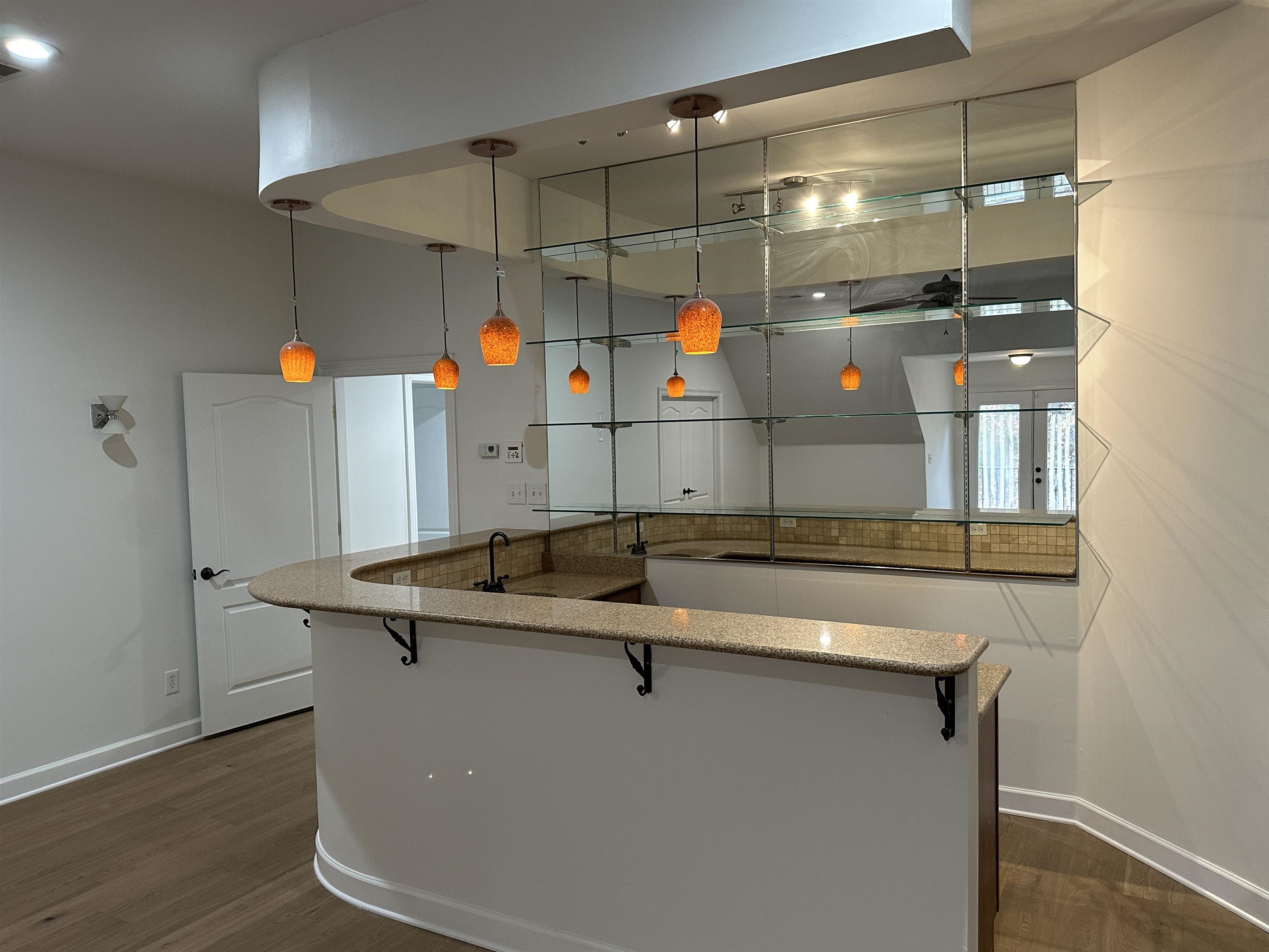 55 Hickory Nut Road Piperton, TN 38017 - Photo 35 of 40 Kitchen featuring a large island, a breakfast bar, stone countertops, baseboards, and dark wood-style flooring