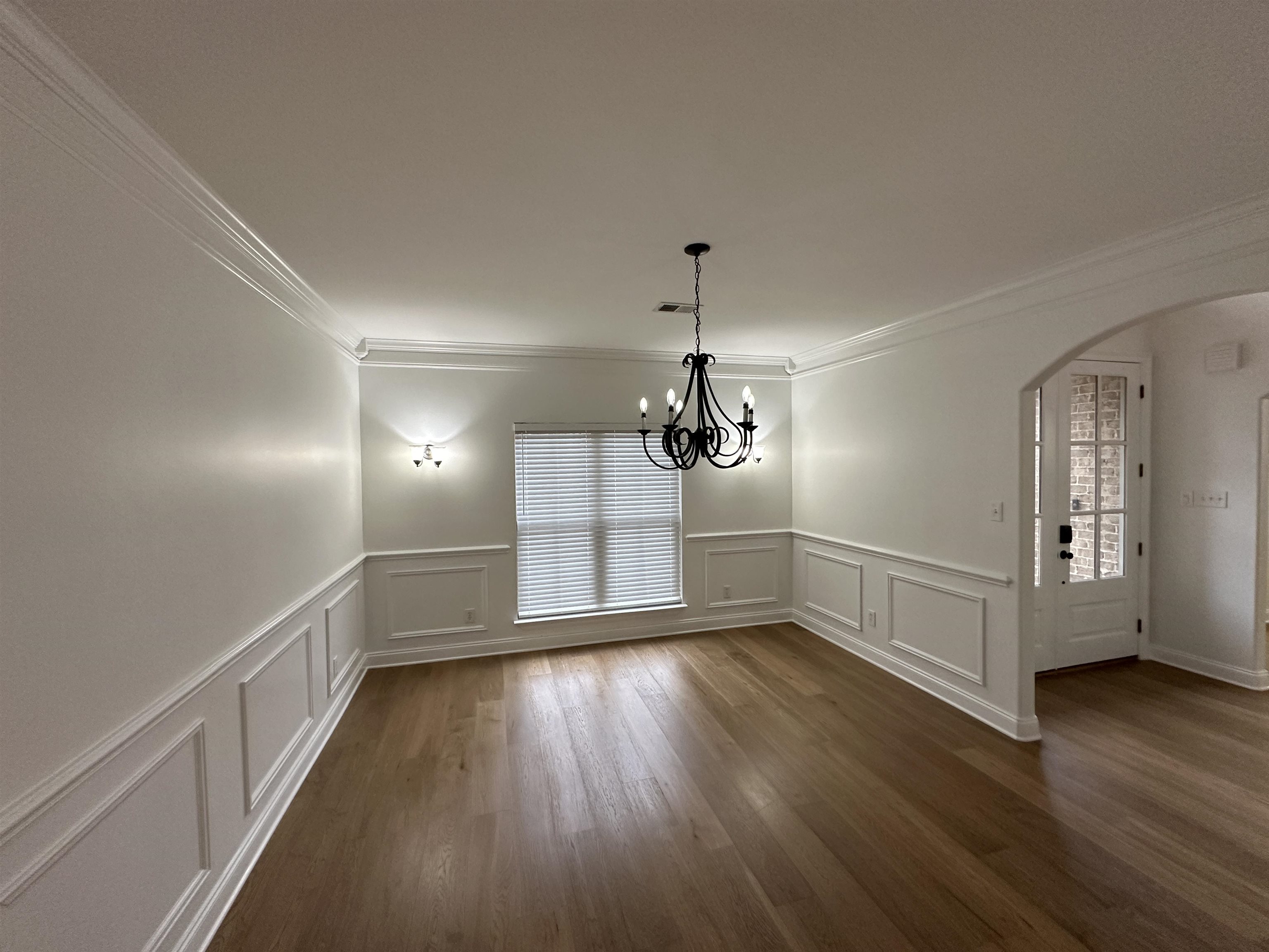 55 Hickory Nut Road Piperton, TN 38017 - Photo 4 of 40 Unfurnished dining area featuring crown molding, a notable chandelier, dark wood-style floors, and arched walkways