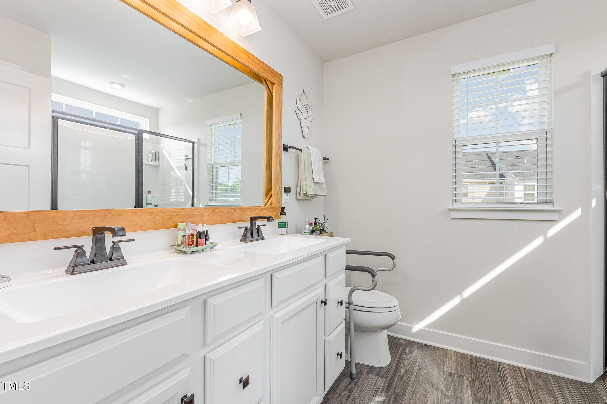 235 Misty Pike Drive Raleigh, NC 27603 - Photo 17 of 29 a bathroom with a toilet a sink a mirror and a window