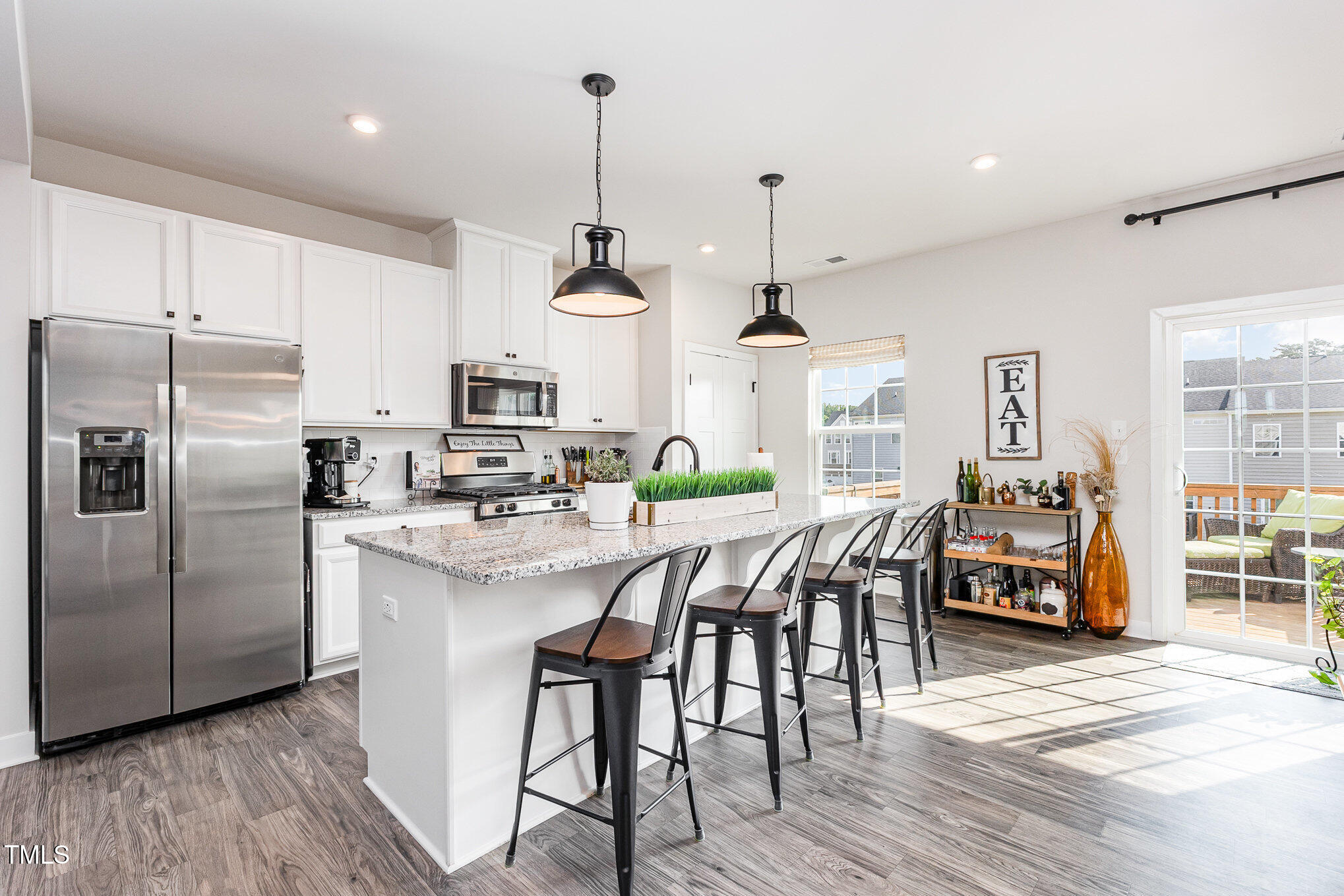 235 Misty Pike Drive Raleigh, NC 27603 - Photo 5 of 29 a kitchen with stainless steel appliances a dining table chairs stove refrigerator and microwave