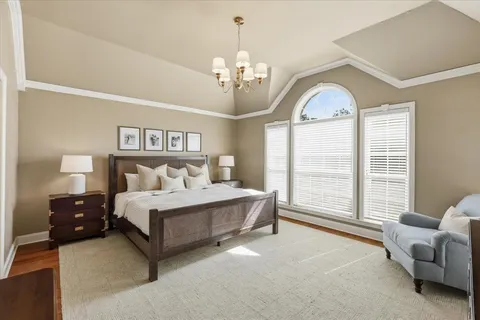 a spacious bedroom with a bed couch and windows