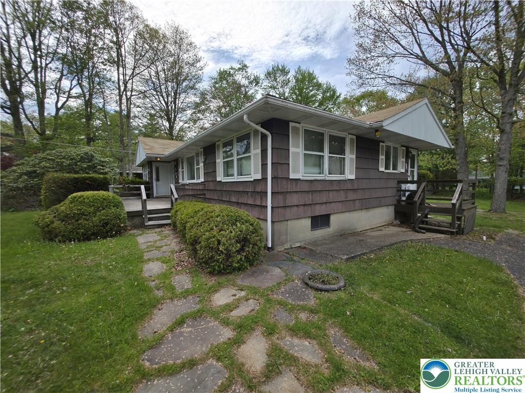 50 Montovision Road Mount Pocono, PA 18344 - Photo 5 of 32 A charming single-story residence with natural wood siding and a welcoming stone path.