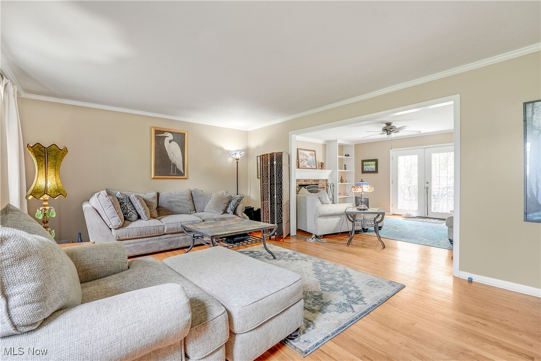 1862 Middleton Road Hudson, OH 44236 - Photo 11 of 32 Living area featuring ornamental molding, light wood-style floors, a brick fireplace, and ceiling fan