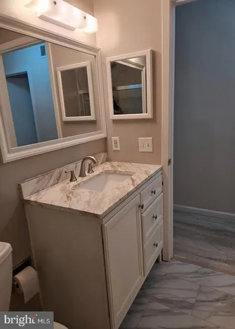 a bathroom with a granite countertop sink and a mirror