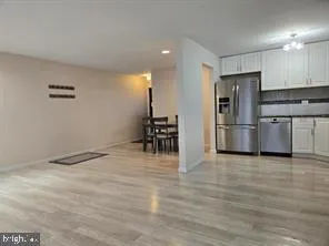 a kitchen with granite countertop a refrigerator cabinets and wooden floor