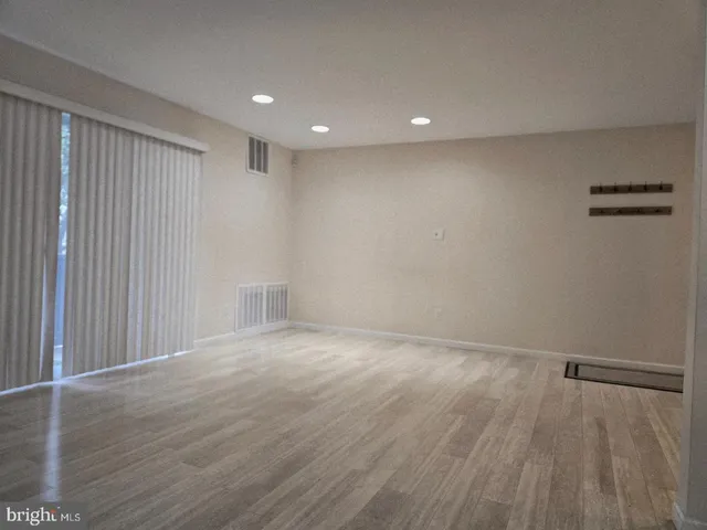 a view of an empty room with wooden floor