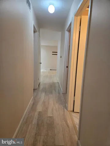 a view of a room with wooden floor and a bathroom