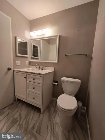 a bathroom with a toilet sink a mirror and vanity